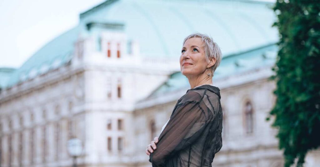 Laya Commenda Expertin für Positive Psychologie steht in Wien und blickt in den Himmel hinauf