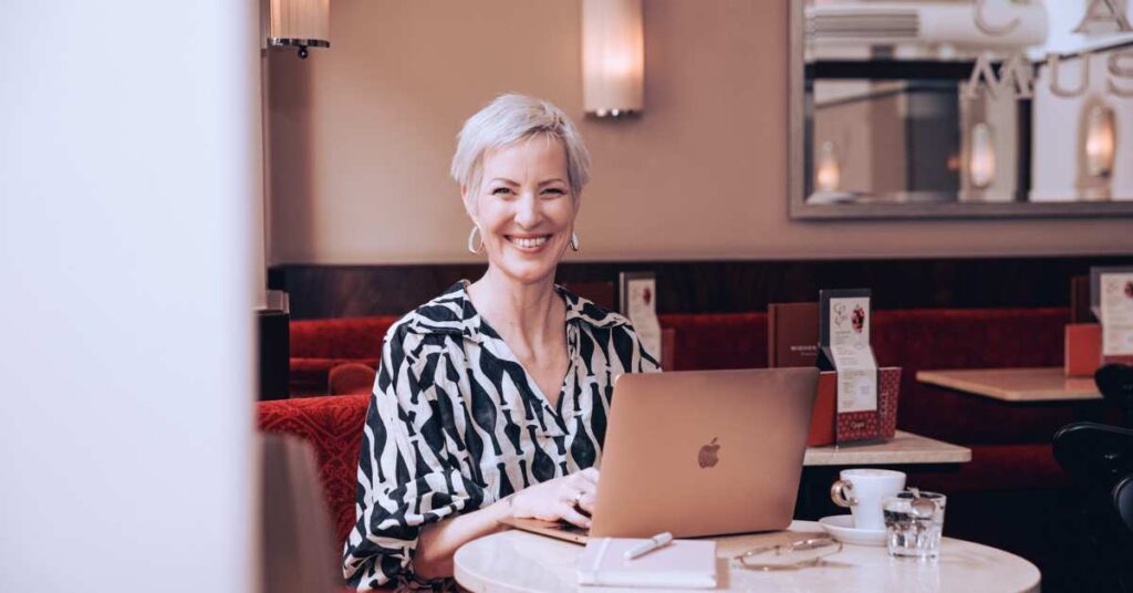 Mindset Expertin Laya Commenda sitzt lächelnd im Café