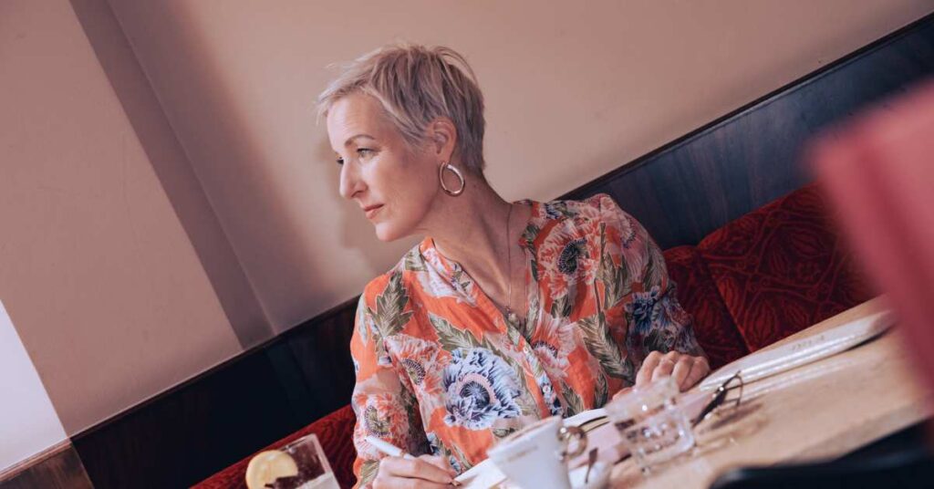 Laya Commenda Expertin für Positive Psychologie sitzt in Wiener Café und blickt zur Seite