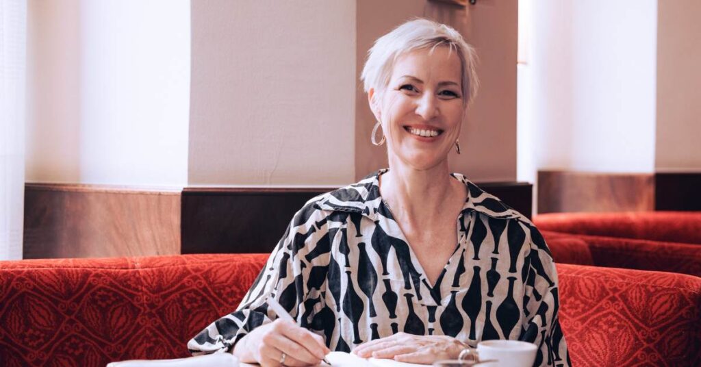 Lebe in Fülle als Frau - Mindset-Expertin Laya Commenda sitzt mit ihrem Journal in einem Wiener Café