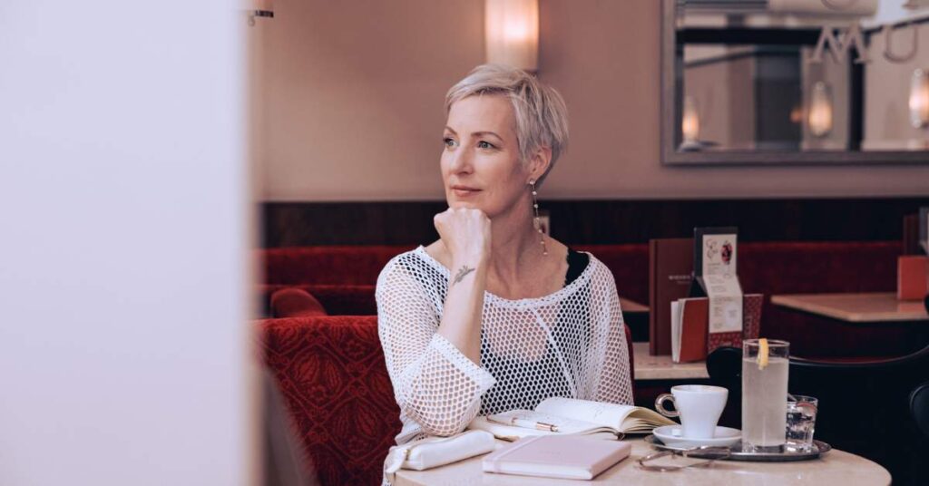 Selbstfürsorge Tipps von Mindset-Expertin Laya Commenda sitzt in einem Wiener Café