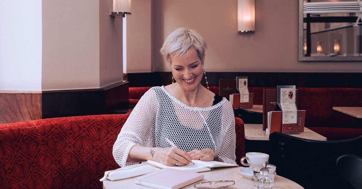 Laya Commenda Expertin für Positive Psychologie schreibt in einem Café