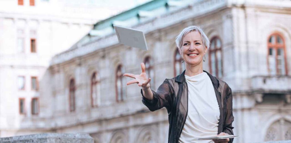 Laya Commenda Mindset Expertin für Lebenslust wirft lachend ein Journal in die Luft