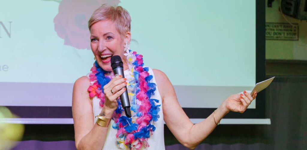 Laya Commenda Mindset- und Empowerment-Expertin führt einen Talk auf der Bühne mit Mikrophon in der Hand