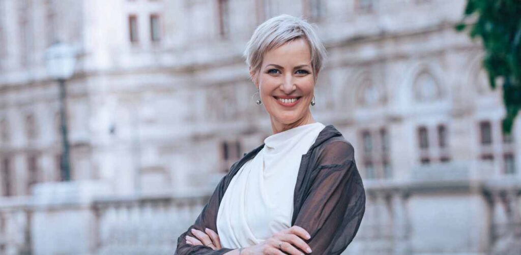 Laya Commenda Expertin für Mind-Management steht in Wien vor einem historischem Gebäude